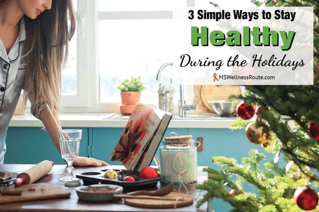 Woman looking at cookbook on table with Christmas tree in kitchen with overlay: Ways to Stay Healthy During the Holidays.