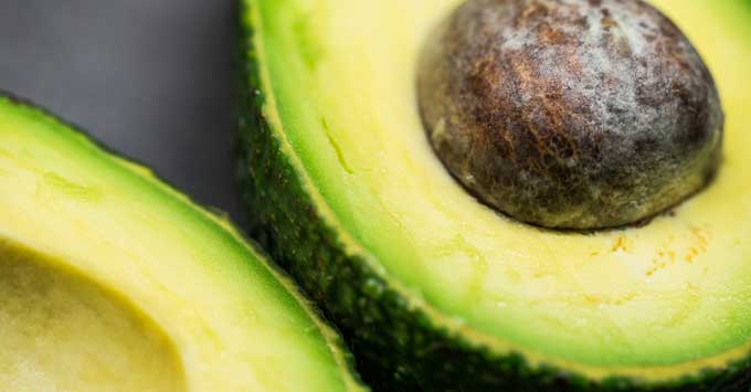 Close up of an avocado sliced in half.