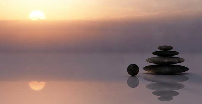 Sunset with meditation rocks balanced on top of each other.