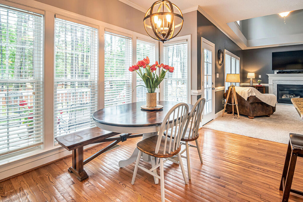 Brown Wooden Round Table With Chairs near windows with mini blinds. 