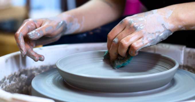 Making a clay dish on a pottery wheel.