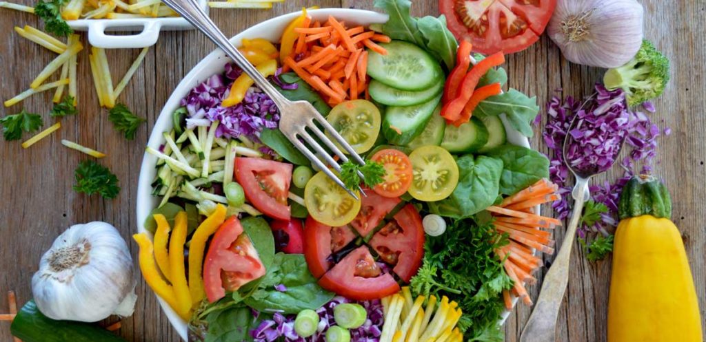 A large colorful salad on a wooden table.