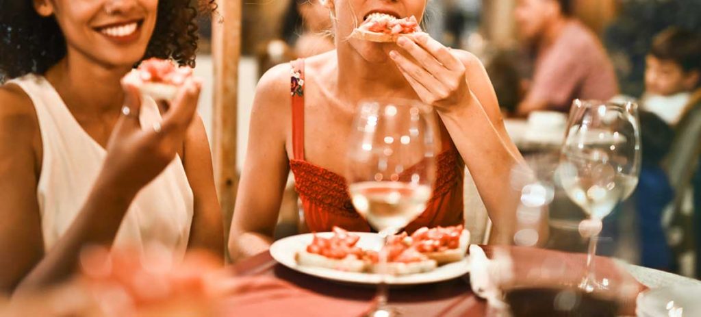 Two young women eating at a restaurant.