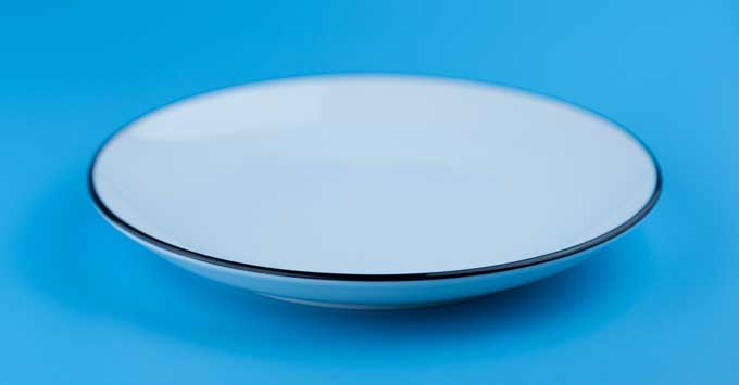 Empty white plate on a blue background.