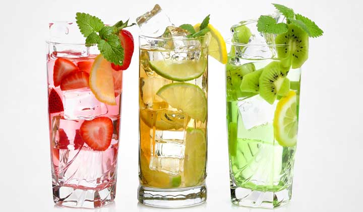 Three glasses of water with fruit slices and mint.