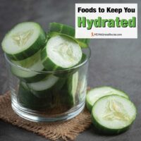 Fresh cucumbers sliced on dark background with overlay: Foods to Keep You Hydrated.