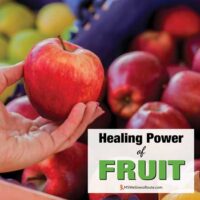 Woman holding an apple at the market with overlay: Healing Power of Fruit