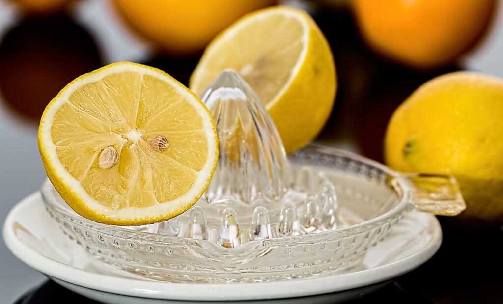 Lemon cut in half on a glass hand juicer.