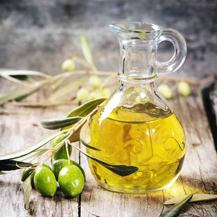 Olive oil with olive branch and olives.