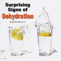 Four glasses of water with lemons with overlay: Surprising Signs of Dehydration