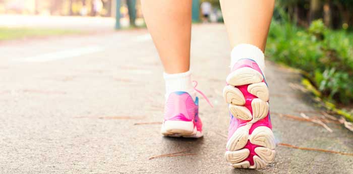 Woman wearing pink sports shoes walking.