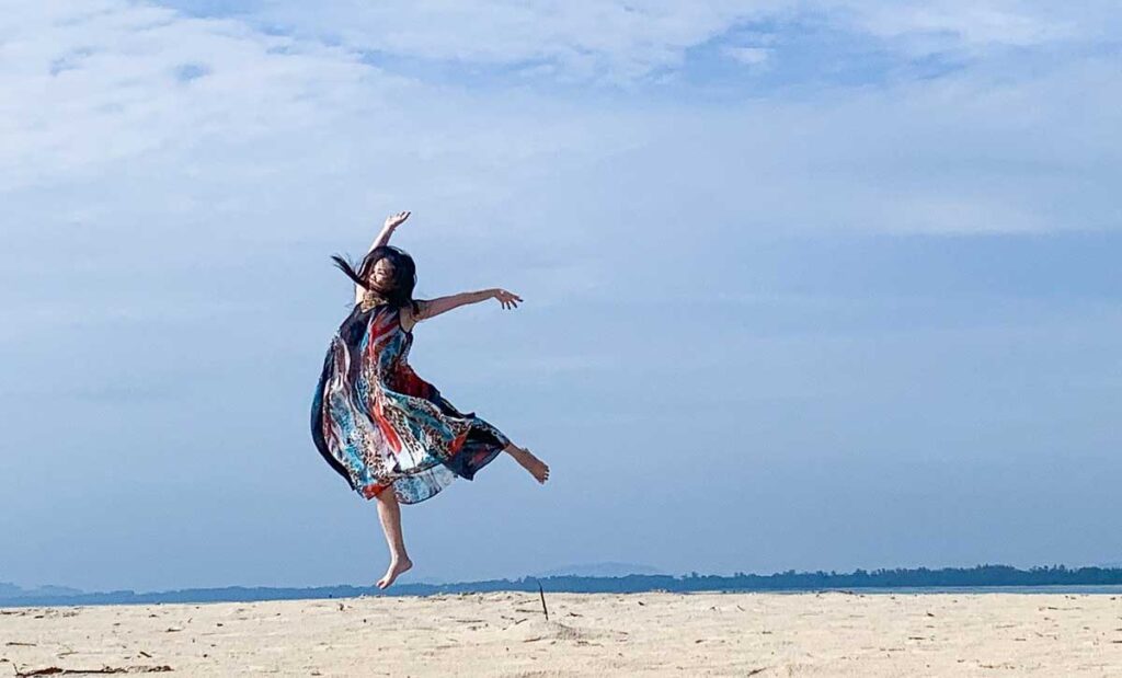 Woman dancing on the beach.