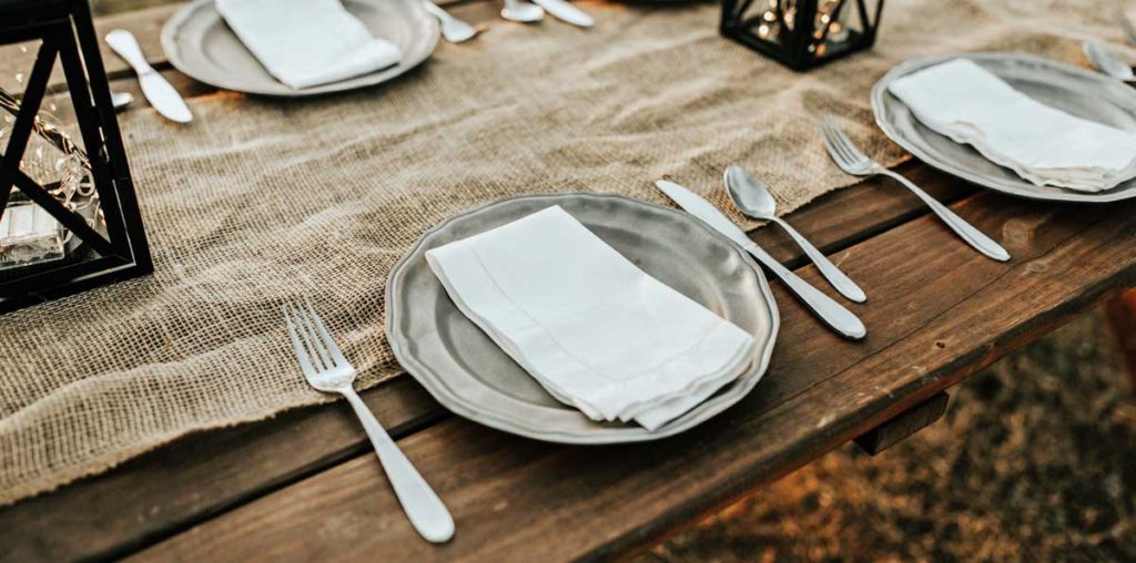 Picnic table with place setting and lanterns.