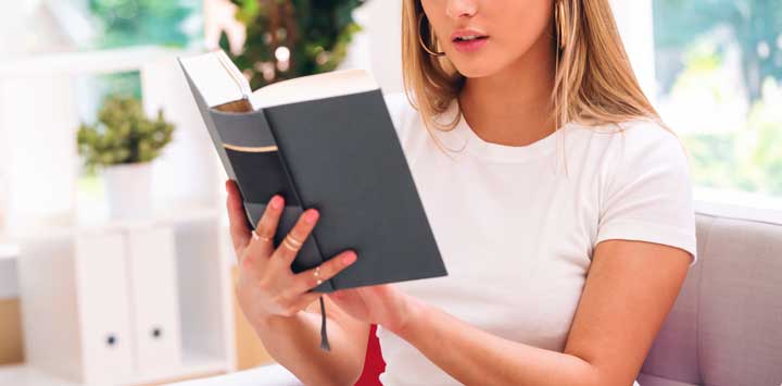 Young blond woman reading a book.