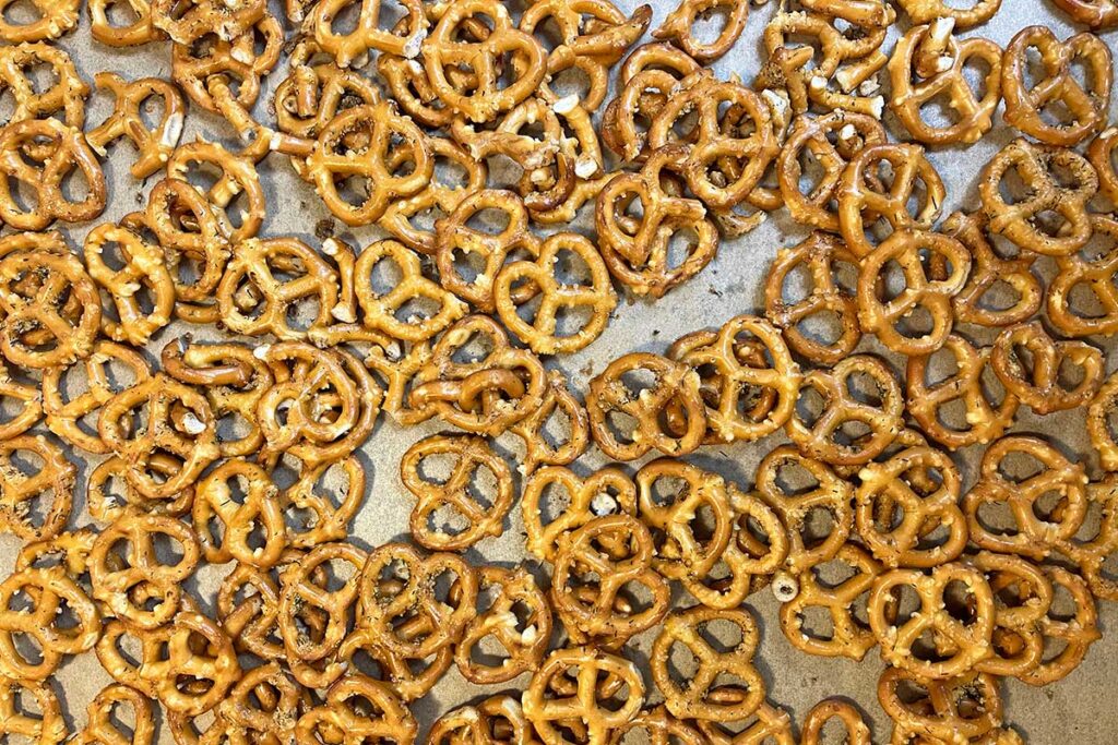 Baked seasoned pretzels on parchment paper.