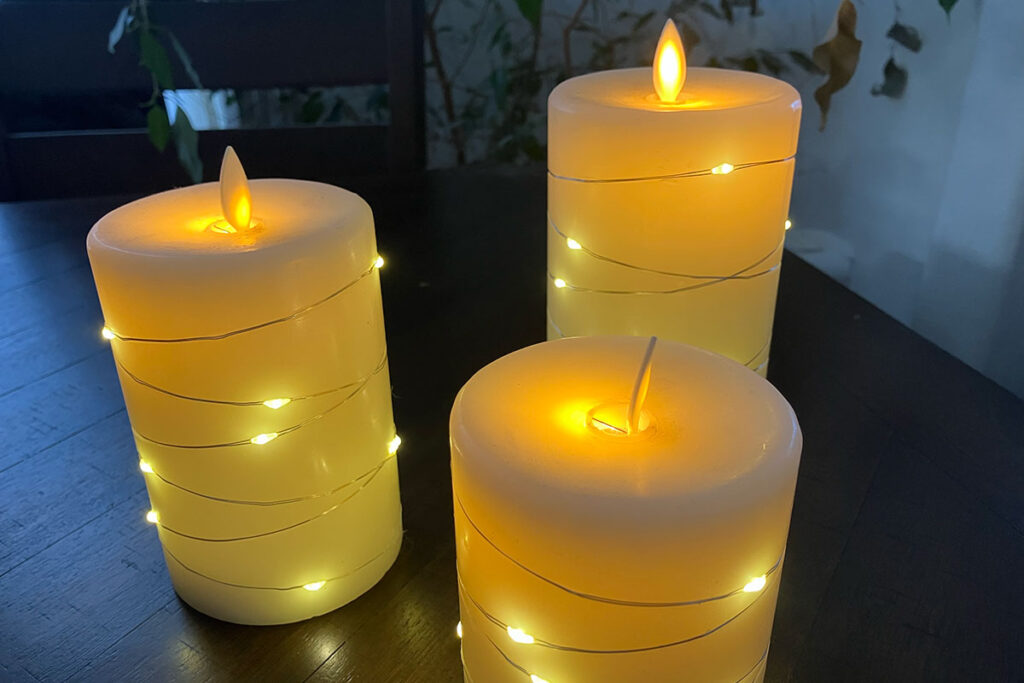 Battery operated candles lit up with lights around candles.