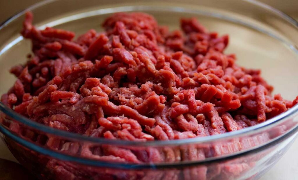 Glass bowl full of ground beef.