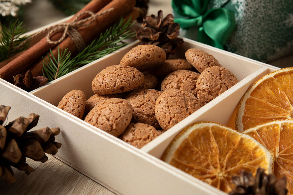 Wooden box with cookies, dried oranges, cinnamon sticks, pine, and pinecones. 