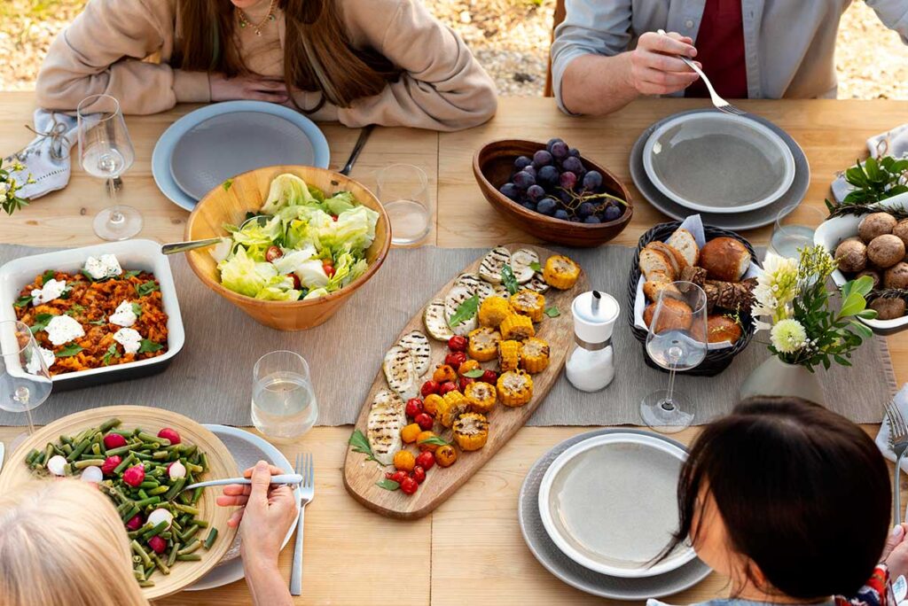 Close up 0f people at table with food.