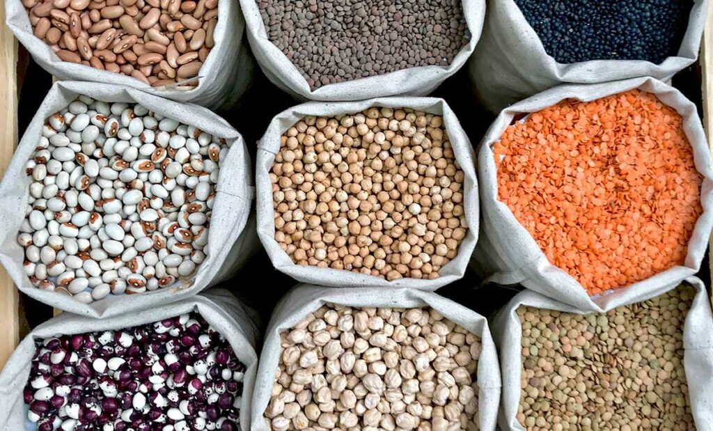 Closeup of different legumes in eco bags.