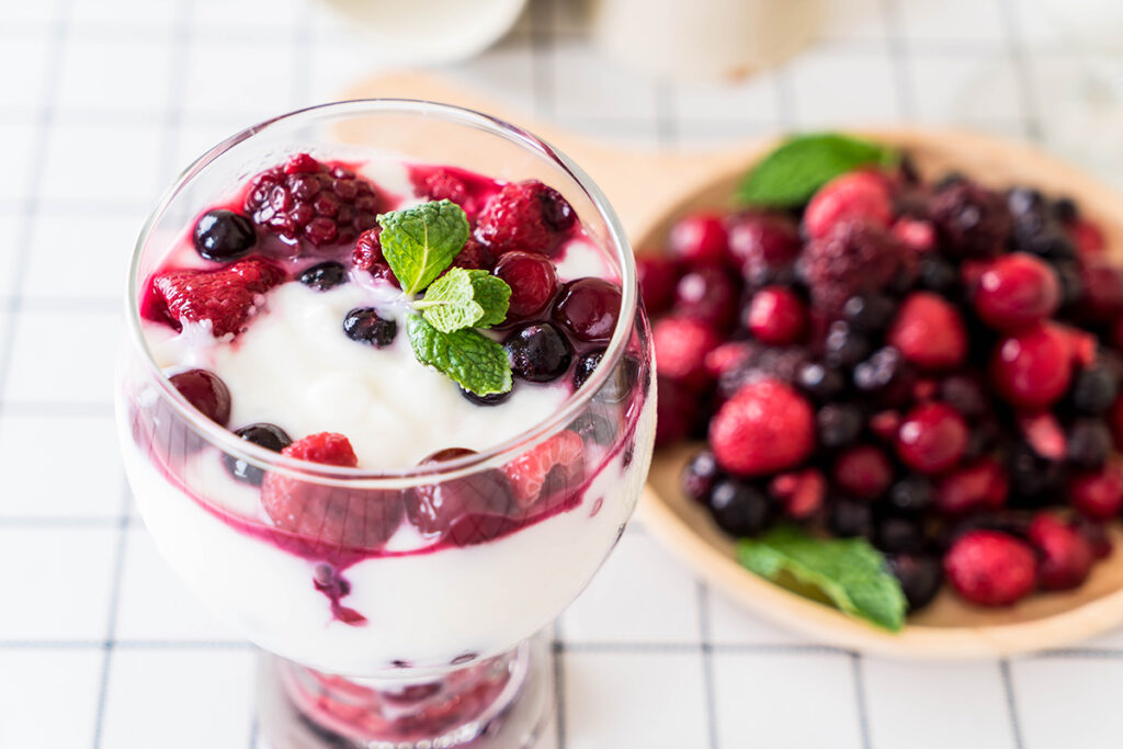 Coconut yogurt with mixed berries in a glass.