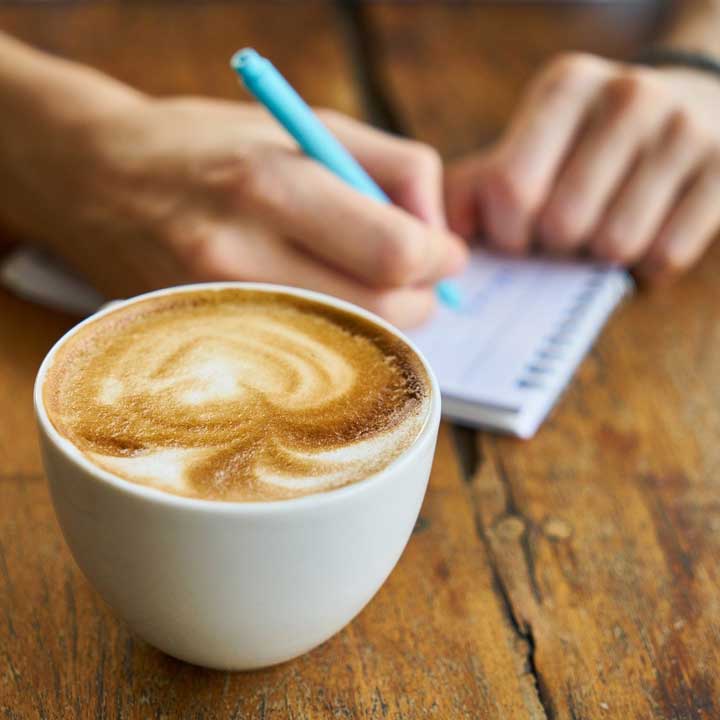 Taking notes with a cup of coffee.