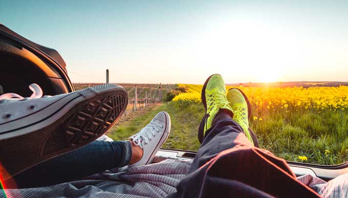 Couple enjoying the sunset from the car trunk.