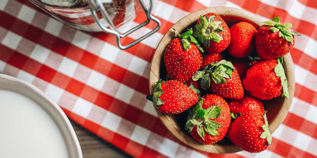 Fresh strawberries in wooden bowl.