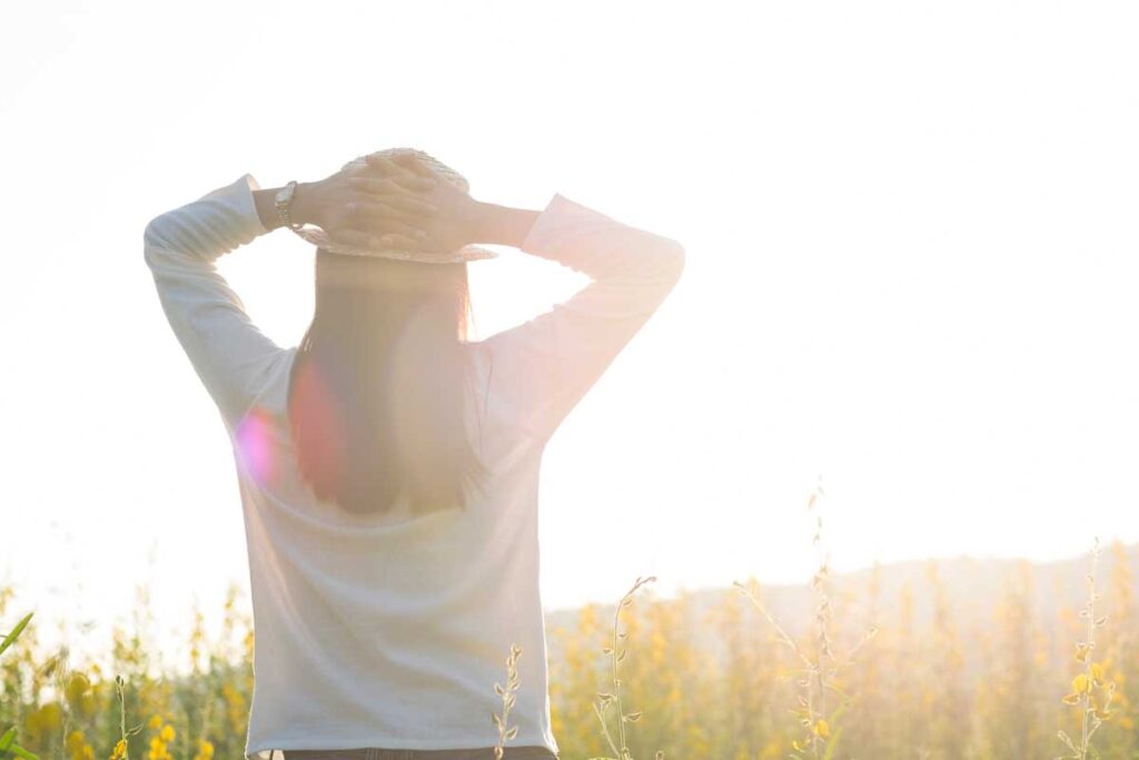 Young woman outdoors enjoying the sunrise.