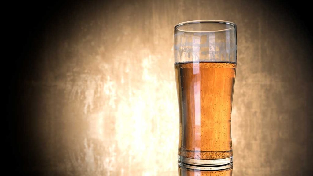 A glass of beer with brown background.