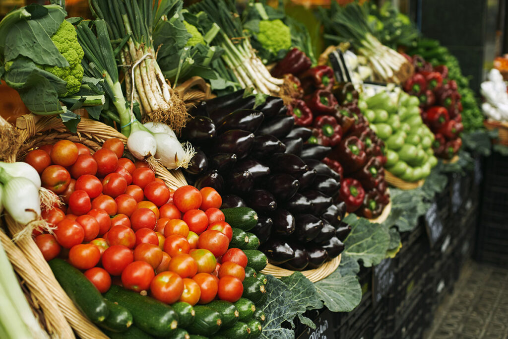 Harvest of fresh vegetable in baskets presented outdoor on market for sale.