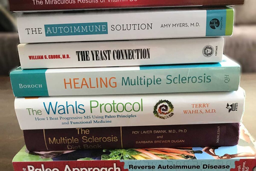 Stack of books on natural MS healing, including The Wahls Protocol Swank diet, and Healing Multiple Sclerosis.