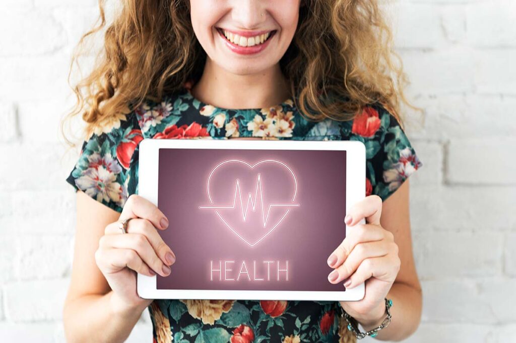 Young woman holding a heart health sign.