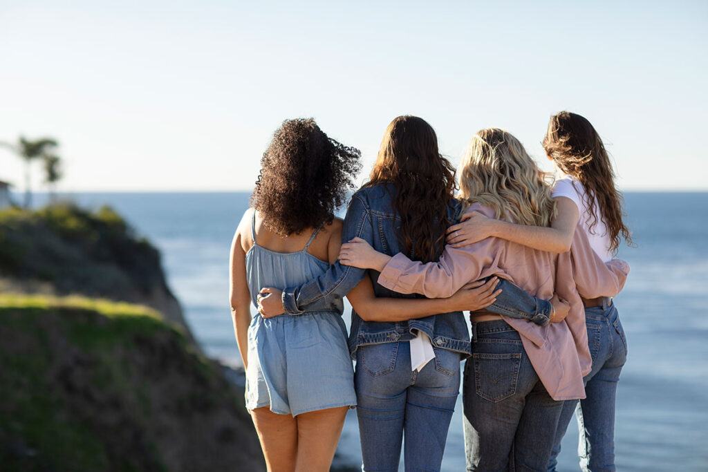 Young woman holding arms together overlooking ocean.