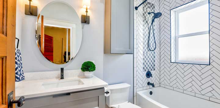 Bathroom with oval mirror and zigzag pattern around tub.