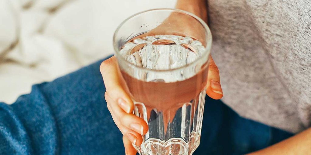 Person holding a glass of water.