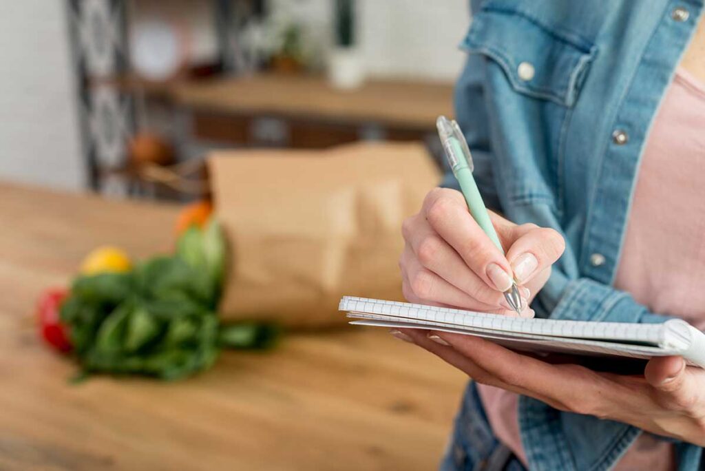 Person writing a recipe in the notebook.