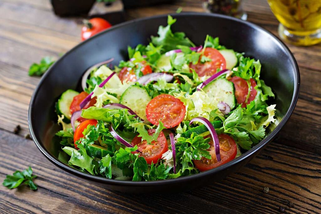 A vegetable salad on a rustic wooden table.