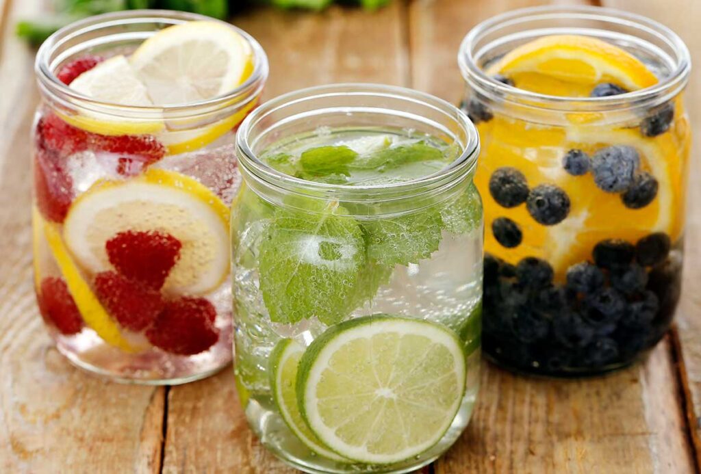 Three glass jars with different flavored water.