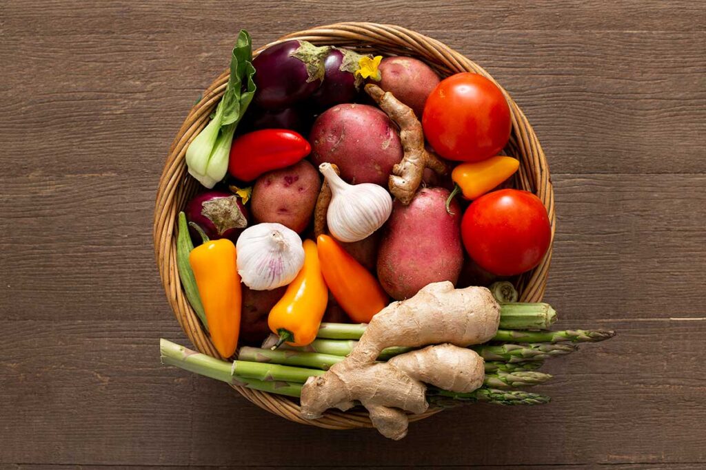 Top view of basket filled with vegetables on wooden table .