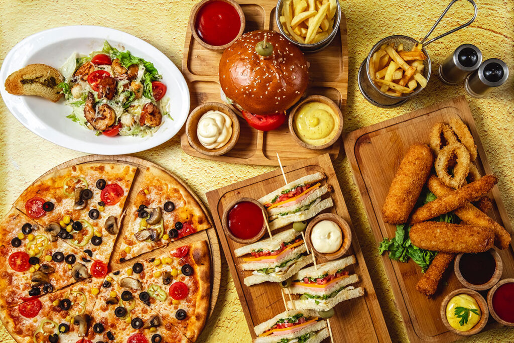 Looking down a a mix of fast food on a yellow table.