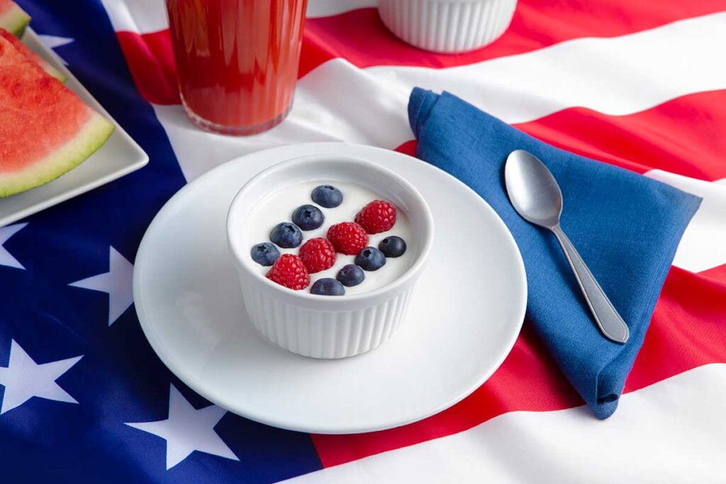 Coconut yogurt with berries on a white plate on an American flag.