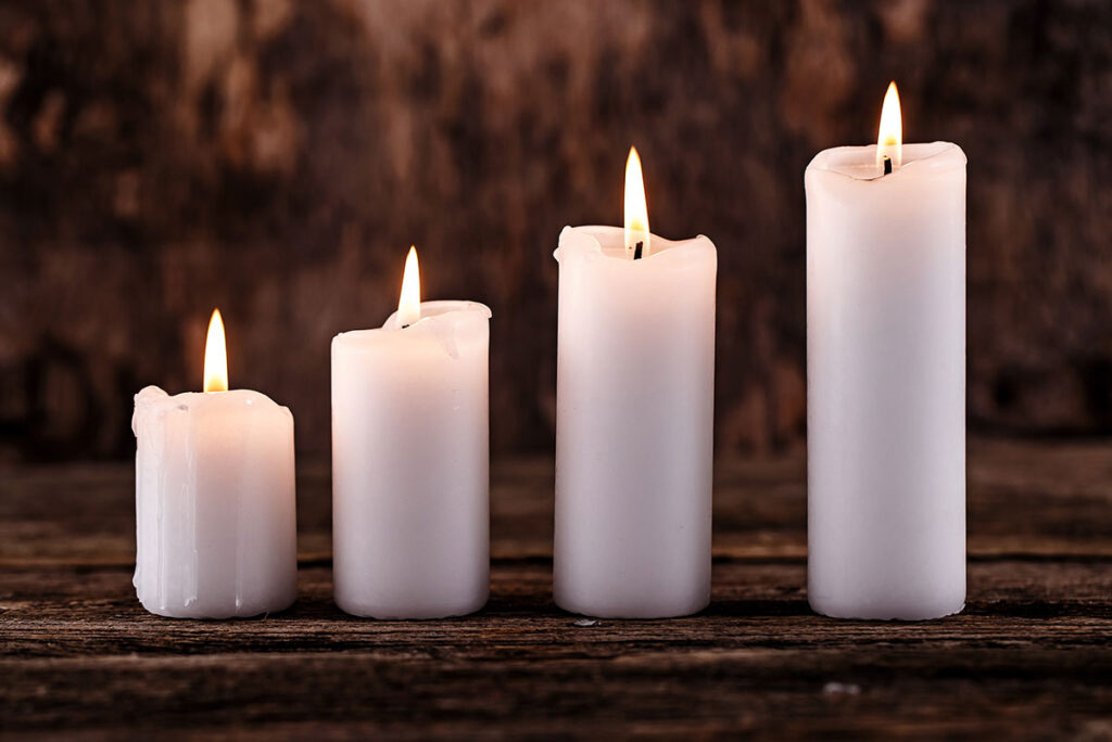 Four white candles lined up.