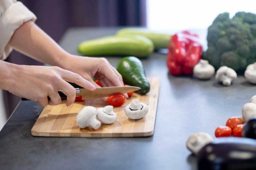 Woman cooking lunch and cutting vegetables.