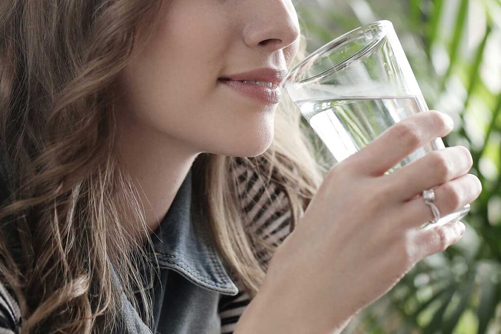 Close up of woman drinking a glass of water.