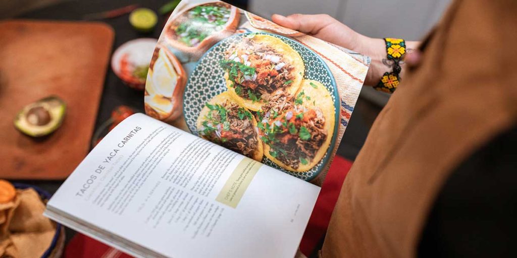 Young woman looking through a cookbook