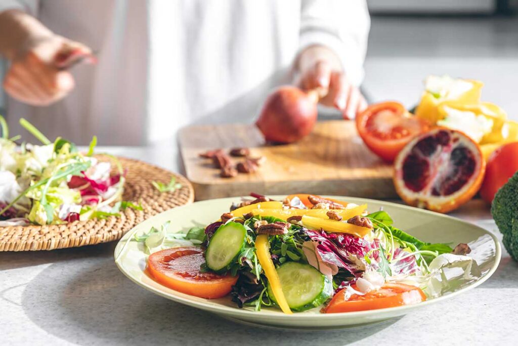 Close up of a woman making a fresh salad.