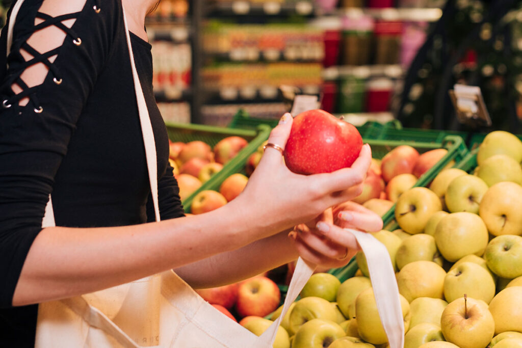 Woman in grocery store shopping for apples.