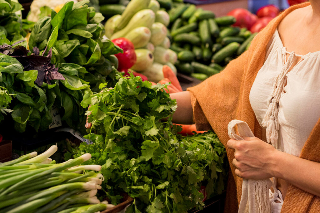 Woman shopping veggies at market place.