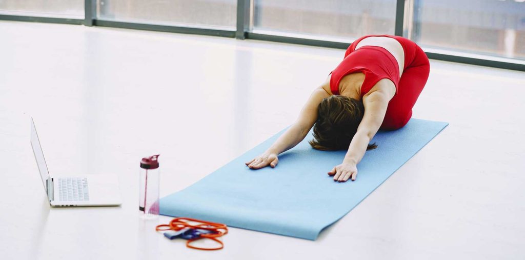 Woman stretching on exercise mat.